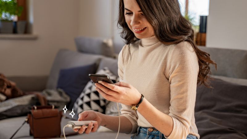 femme chargeant son téléphone avec une batterie